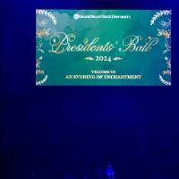 A graphic on screen at Presidents' Ball that reads "Presidents' Ball 2024. Welcome to an evening of enchantment."